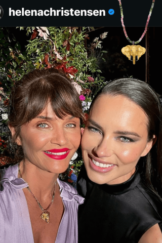 Two women posing together with a decorative background