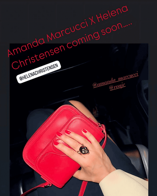 Hand holding a red handbag with text about Amanda Marcucci and Helena Christensen collaboration.
